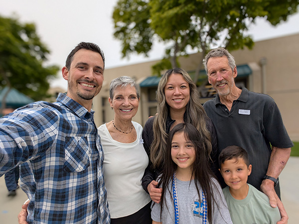 The owners of All Good Eats & Drinks smiling and welcoming customers outside their local Thousand Oaks restaurant.