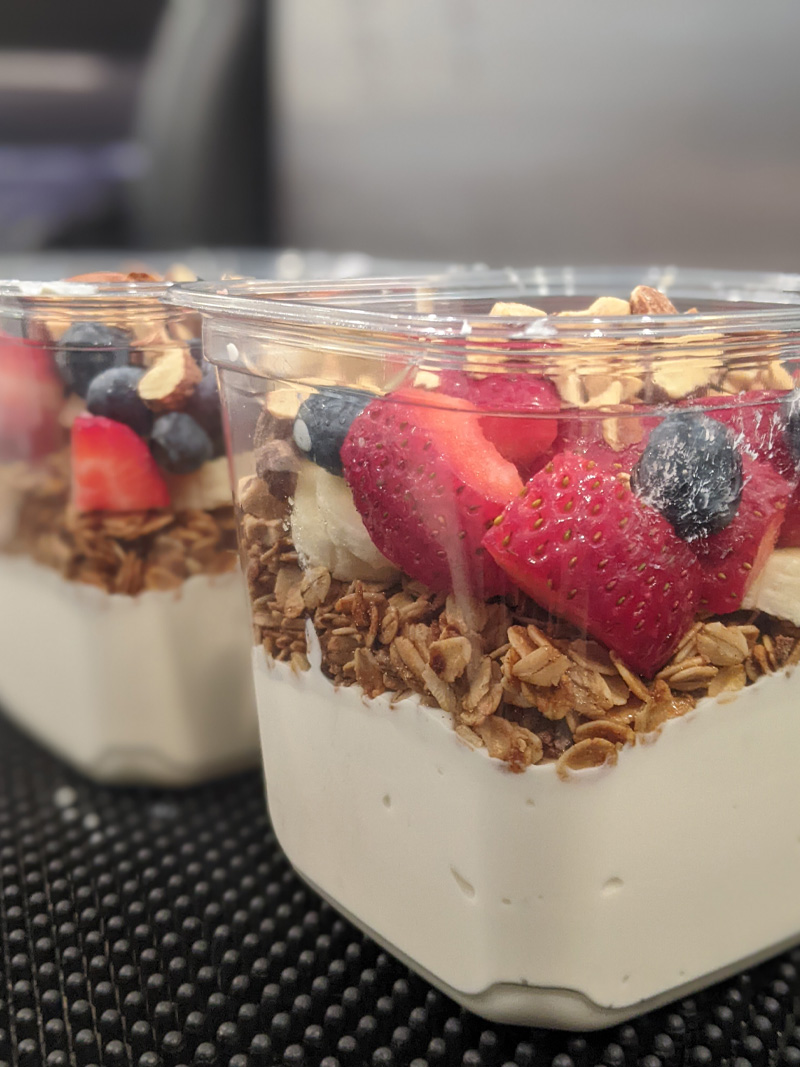 Layered yogurt parfait topped with fresh strawberries, blueberries, and crunchy toasted oats at All Good Eats & Drinks.